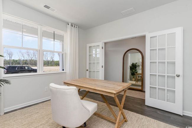 Dining area with arched walkways, baseboards, wood finished floors, and visible vents | Image 11