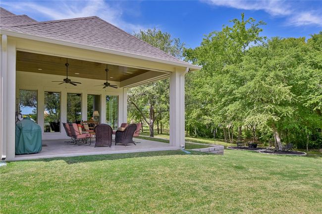 View of green lawn with a patio and ceiling fan | Image 24