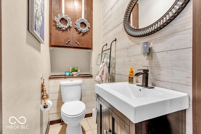 half bathroom featuring tile patterned floors, vanity, and wooden walls | Image 28
