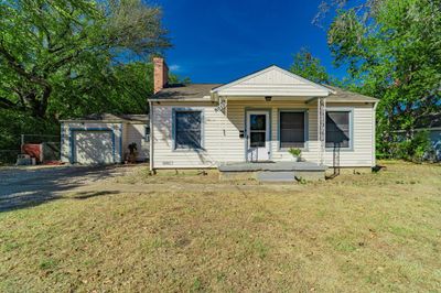 View of front facade with central AC, a garage, a front yard, and an outbuilding | Image 1