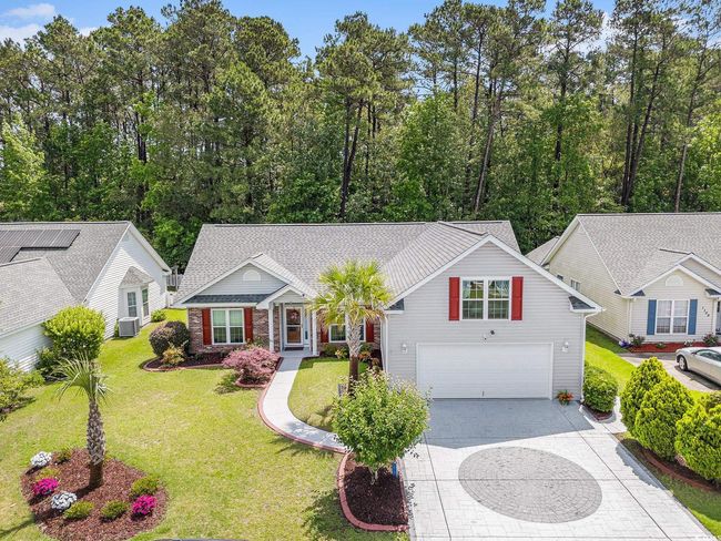 Traditional home with concrete driveway, an attached garage, a front lawn, brick siding, and central AC unit | Image 5