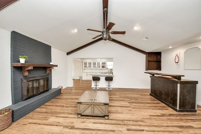 Vaulted ceilings with beams add character to this open-concept living space, seamlessly connected to the kitchen for easy entertaining. | Image 6
