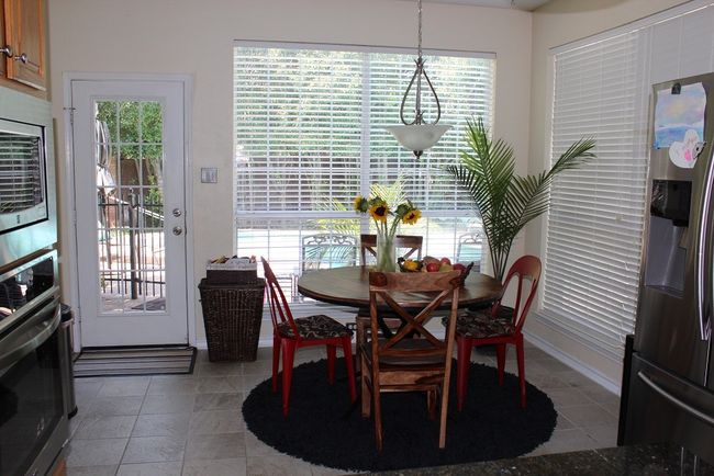 Dining space with healthy amount of natural light and light tile patterned floors | Image 5