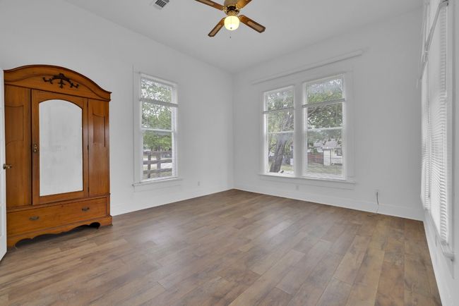 Empty room featuring plenty of natural light, a ceiling fan, baseboards, and wood finished floors | Image 9