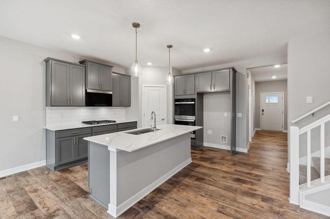 Stainless appliances, quartz countertops, backsplash and walk-in pantry with plenty of space for your culinary creations! Model photo. Options and colors will vary. | Image 4