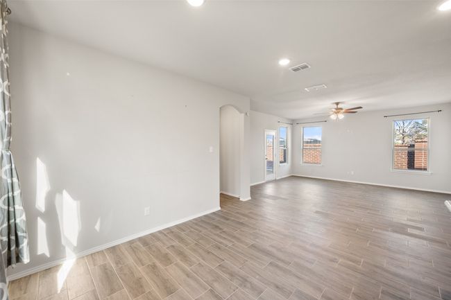 Unfurnished room featuring arched walkways, light wood-style floors, and visible vents | Image 27