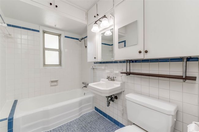 Bathroom featuring toilet, shower / bath combination, tile walls, tile patterned floors, and tasteful backsplash | Image 22
