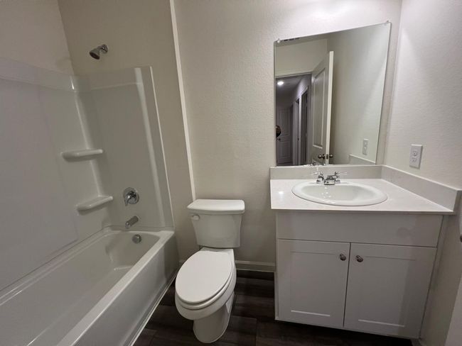 Full bath featuring vanity, toilet, bathing tub / shower combination, and wood finished floors | Image 27