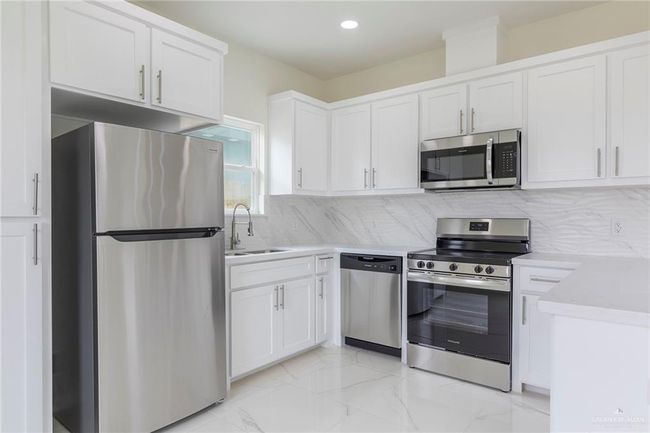 Kitchen with Stainless Steel Appliances, White Wood Cabinets, Quarz Counter-Tops. | Image 12