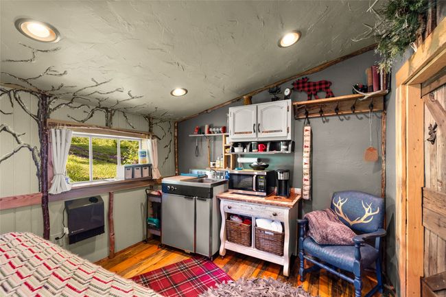 Cabin Studio with Kitchenette with stainless steel microwave, lofted ceiling, white cabinetry, light wood-style floors, and recessed lighting | Image 44