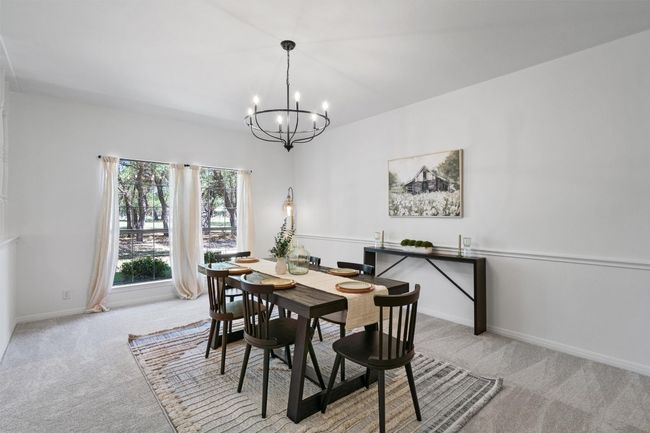 Dining room with baseboards, carpet floors, and a notable chandelier | Image 6
