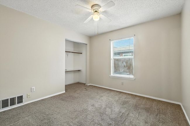 Unfurnished bedroom with carpet, a textured ceiling, a closet, and a ceiling fan | Image 15