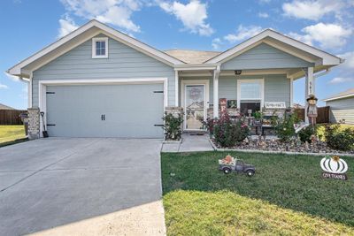 Craftsman-style house with covered porch, a front yard, and a garage | Image 2