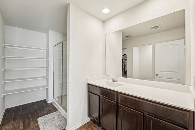 Full bathroom with vanity, wood finished floors, visible vents, baseboards, and a shower stall | Image 19