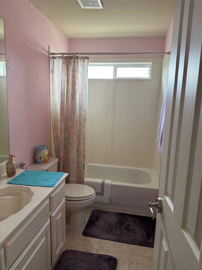 Full bath featuring shower / tub combo with curtain, tile patterned floors, vanity, and toilet | Image 38
