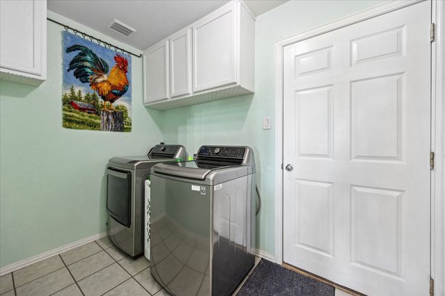 Functional laundry room with ample storage space and convenient access to the garage for added convenience. | Image 23