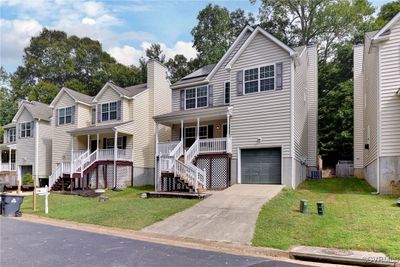 View of front of property featuring a porch, a garage, and a front yard | Image 1