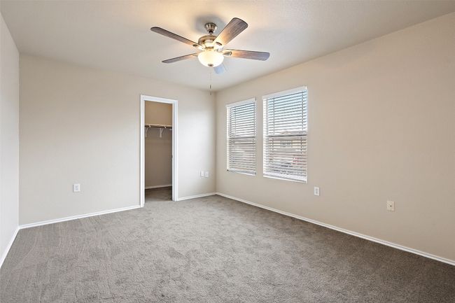 Unfurnished bedroom with carpet, a spacious closet, and a ceiling fan | Image 28