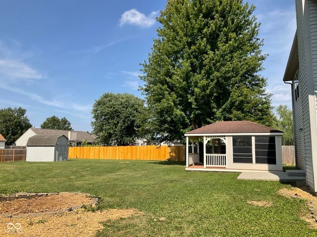 Massive fenced in backyard, with large storage/mini barn and screened in gazebo with treck decking porch. Great space for entertaining, play house, parties, etc. | Image 44