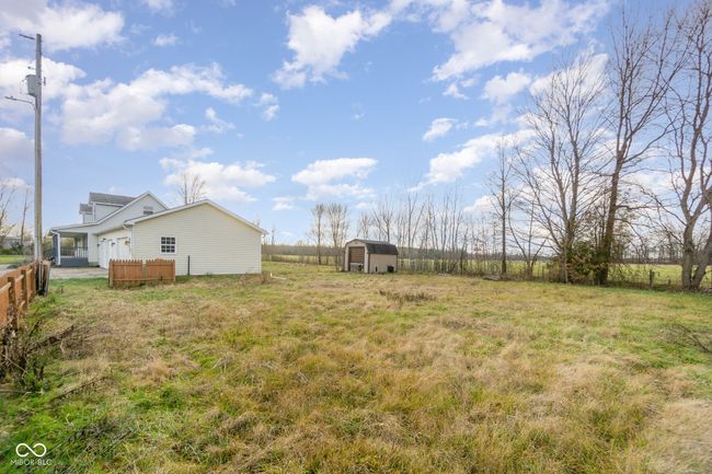 view of yard with a storage unit, fence, an outdoor structure, and an attached garage | Image 26