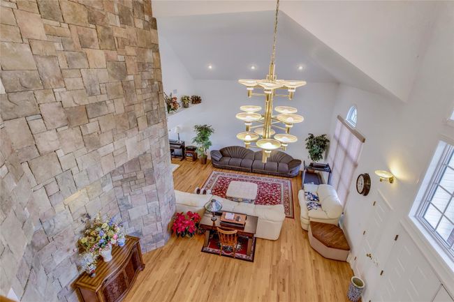 Living room with an inviting chandelier, high vaulted ceiling, and hardwood / wood-style floors | Image 4