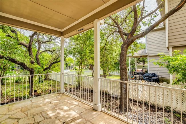 The outdoor living area features a covered patio with flagstone, along with an additional large flagstone patio—perfect for entertaining. The fenced backyard offers plenty of space and is shaded by mature trees, creating a peaceful and private retreat. | Image 21