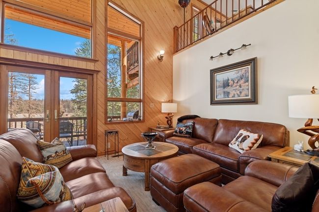 Living room with towering ceilings and french doors that open to covered deck and access to hot tub. | Image 43