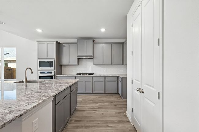 Kitchen with gray cabinetry, appliances with stainless steel finishes, recessed lighting, light wood finished floors, and under cabinet range​​‌​​​​‌​​‌‌​‌‌​​​‌‌​​‌‌​‌​​​​​‌ hood | Image 4