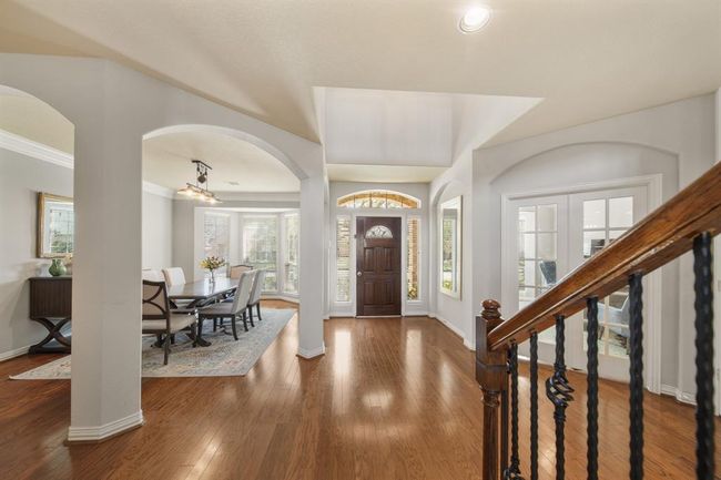 Included is a wood-stained & leaded glass front door with keyless entry flanked by sidelights with blinds & and an arched transom above. The French doors on the right open to a private study. | Image 4