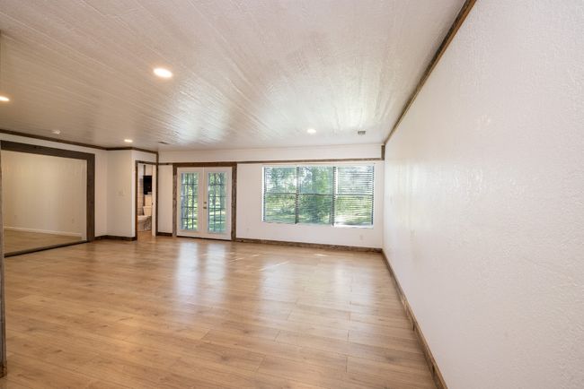 Spare room featuring baseboards, recessed lighting, french doors, crown molding, and light wood-style floors | Image 4