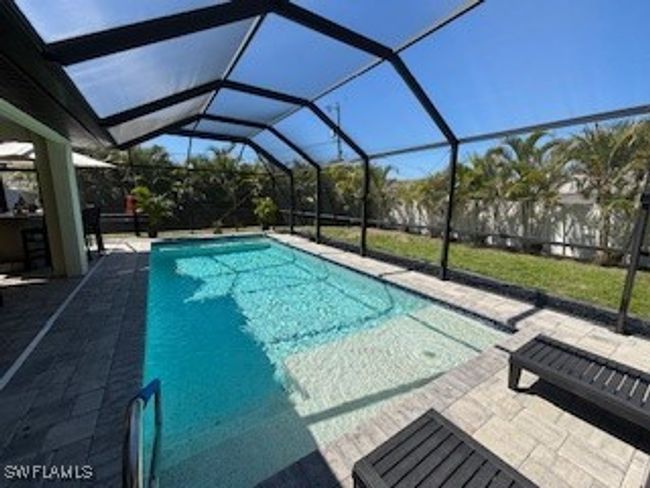 Outdoor pool with glass enclosure and a patio area | Image 35