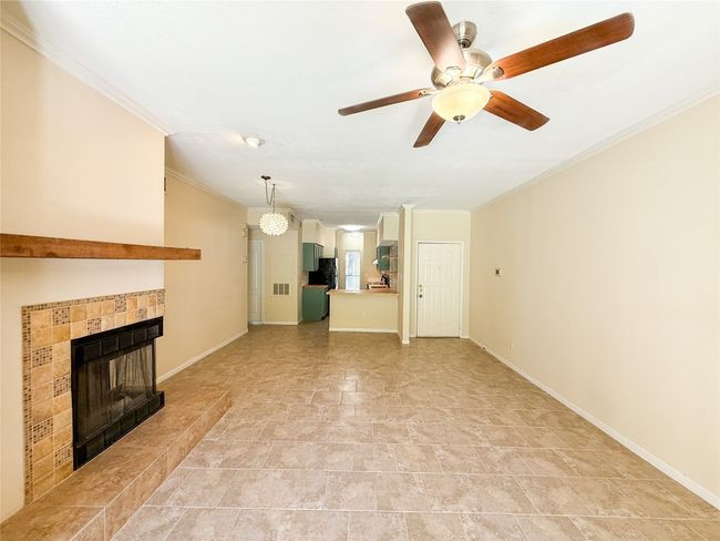 Unfurnished living room featuring ornamental molding, a ceiling fan, and a tile fireplace | Image 11