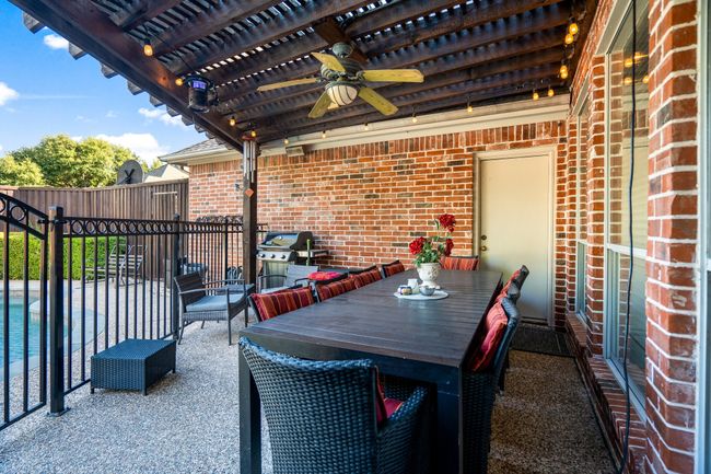 View of patio featuring a pergola, a ceiling fan, outdoor dining area, fence, and a fenced in pool | Image 33