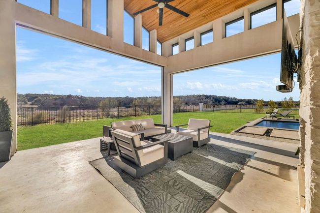 View of patio with a pool, outdoor lounge area, a rural view, a fenced backyard, and ceiling fan | Image 34