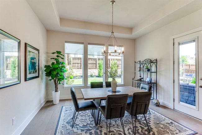 Dining room featuring plenty of natural light, a chandelier, a tray ceiling, and wood finished floors | Image 13