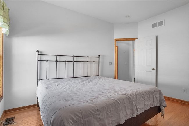 Bedroom featuring baseboards, wood finished floors, and visible vents | Image 28