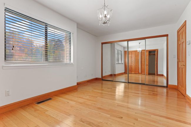 Unfurnished bedroom featuring a chandelier, light wood-style flooring, baseboards, and a closet | Image 28