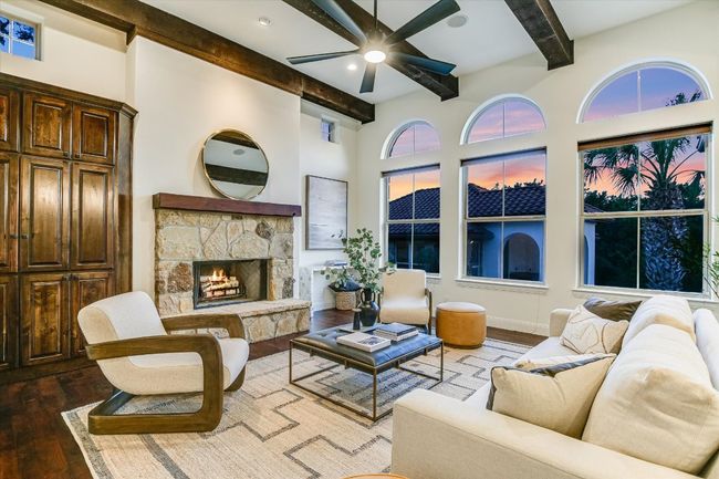 Living area featuring, wood beamed ceiling, and mesquite hardwood flooring, with fireplace and built in cabinetry | Image 12