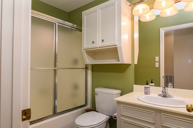 Bathroom with toilet, vanity, and bath / shower combo with glass door | Image 16
