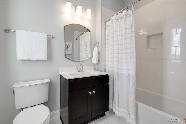 Bathroom featuring toilet, tile patterned floors, shower / bath combo with shower curtain, and vanity | Image 39