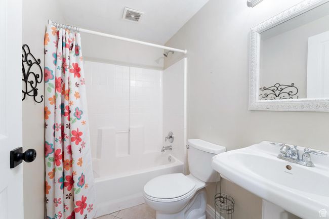 Full bathroom with shower / bathtub combination with curtain and tile patterned floors | Image 26