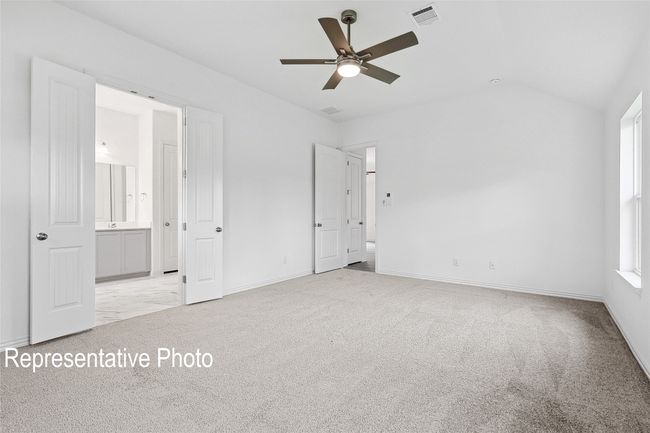 Unfurnished bedroom featuring connected bathroom, baseboards, light colored carpet, lofted ceiling, and visible vents | Image 9