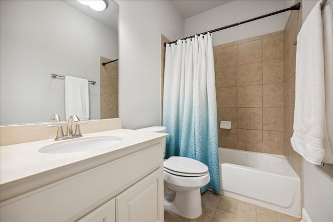 Bathroom featuring tile patterned floors, toilet, vanity, and shower / bath combo | Image 34