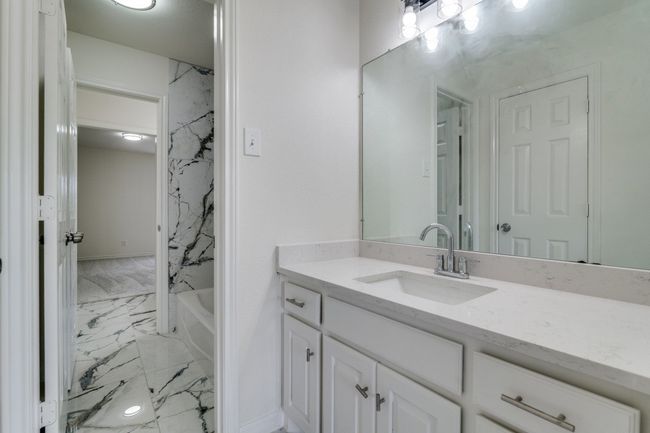 Bathroom featuring marble look tile flooring, vanity, and shower / washtub combination | Image 18