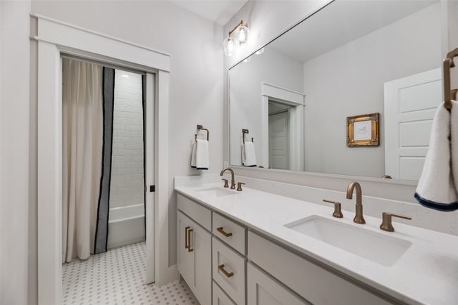 Bathroom with tile patterned floors, double vanity, and shower / bath combination with curtain | Image 32
