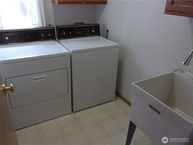 Laundry room includes washer, dryer, and utility tub. | Image 23