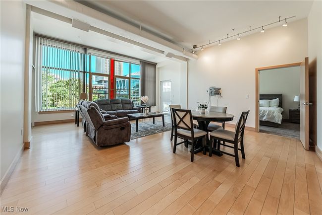 Dining space with light wood-style floors and rail lighting. | Image 12