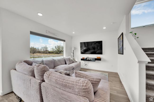 Living area featuring light wood finished floors, stairs, recessed lighting, and baseboards | Image 9