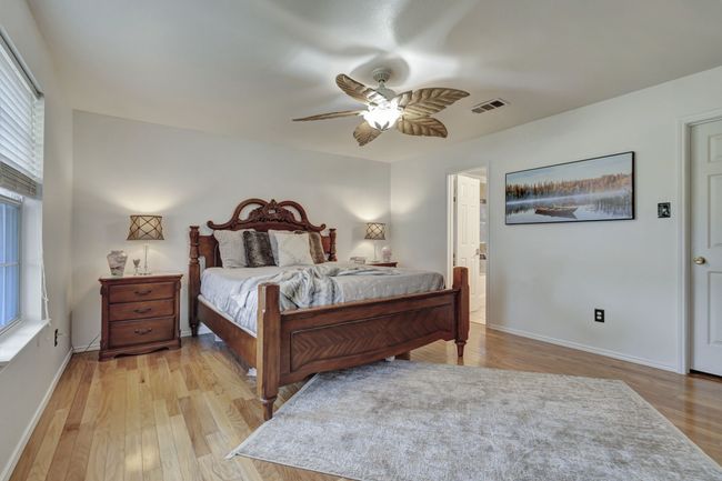 Bedroom with ceiling fan, light hardwood / wood-style floors, and multiple windows | Image 22