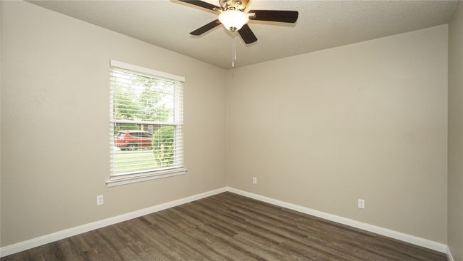The flex room offers luxury vinyl plank floors, a lighted ceiling fan, and a window overlooking the front yard | Image 4